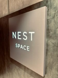 Nest Space sign mounted on a dark wall