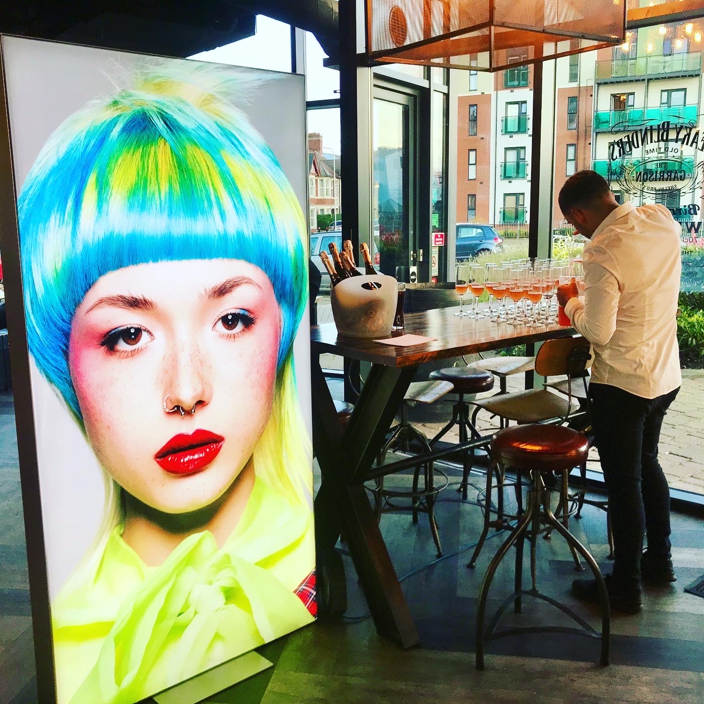 Illuminated portrait lightbox display beside a bar