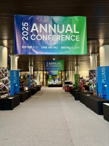2025 Annual Conference banner hanging above an exhibition hall aisle with branded stands