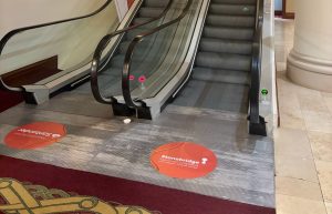 Circular orange floor graphics at the foot of an escalator