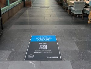 Wyndham Arcade floor graphic with QR code in a paved arcade