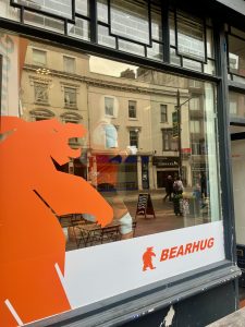 Orange bear window graphic and Bearhug logo on a shop window