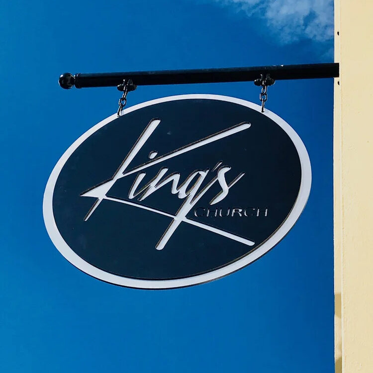 Oval King's hanging sign against a blue sky